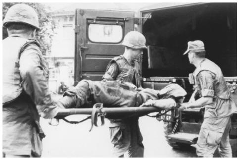 American soldiers move the body of a comrade who died in the 1968 bombing of the United States bachelor officers
